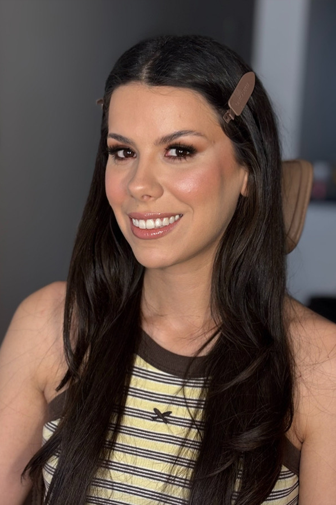 Cliente sorrindo com maquiagem social iluminada