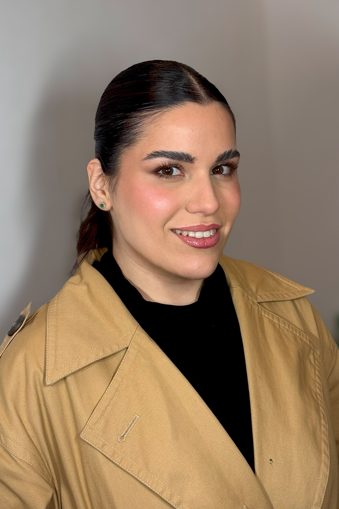 Cliente com blazer bege e maquiagem social sofisticada