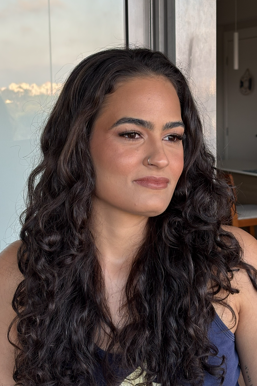 Cliente com cabelo cacheado e make social natural